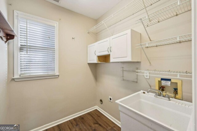 laundry room featuring sink, hookup for a washing machine, dark wood-type flooring, hookup for an electric dryer, and cabinets