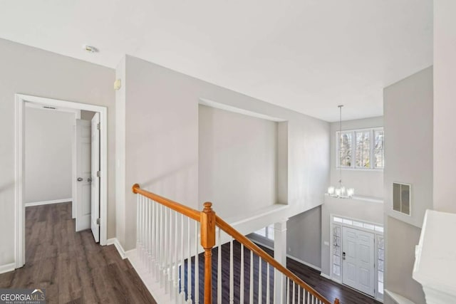 hall featuring dark hardwood / wood-style flooring and a notable chandelier