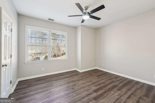 spare room featuring ceiling fan and dark wood-type flooring