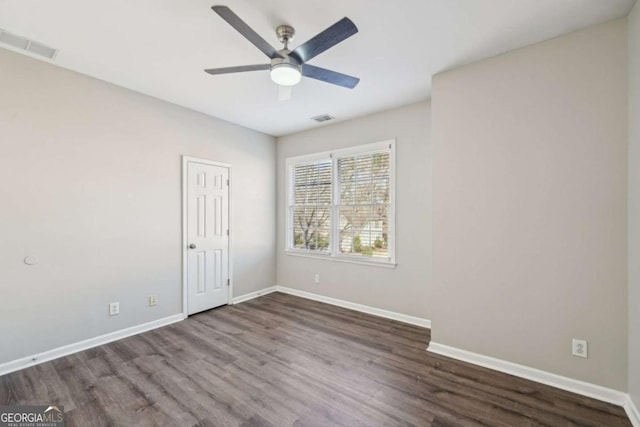 empty room featuring ceiling fan and dark hardwood / wood-style flooring