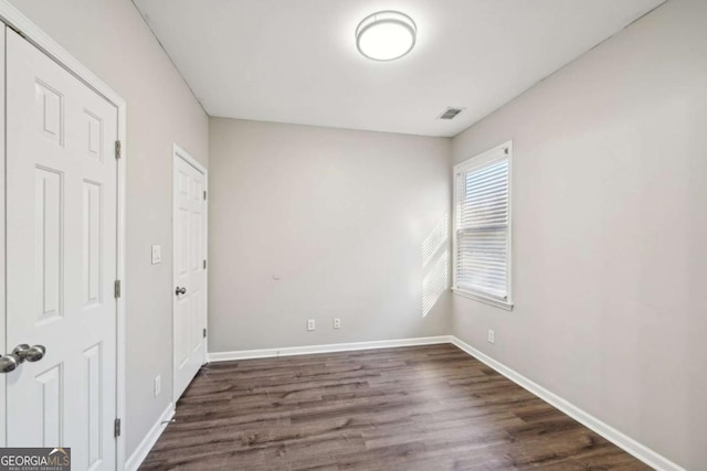 spare room featuring dark wood-type flooring