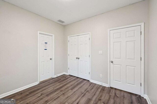 unfurnished bedroom with dark hardwood / wood-style floors