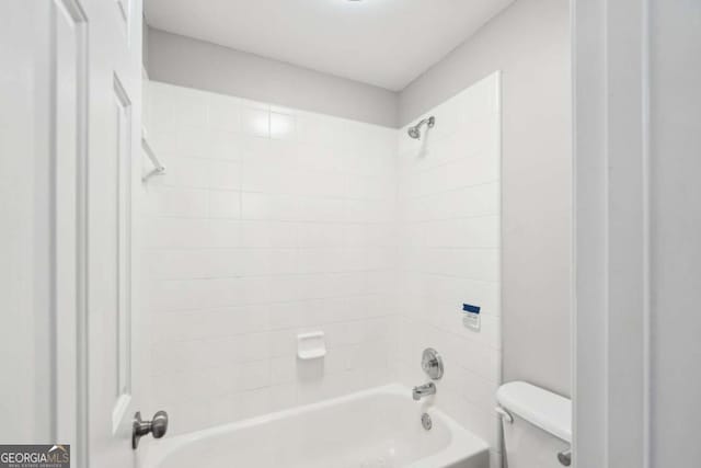 bathroom with toilet and tiled shower / bath