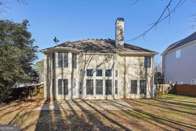 back of property with a lawn and a patio