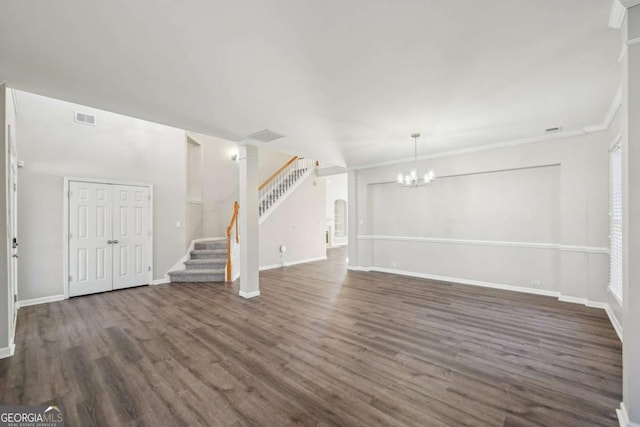 unfurnished living room with a chandelier, dark hardwood / wood-style floors, and ornamental molding