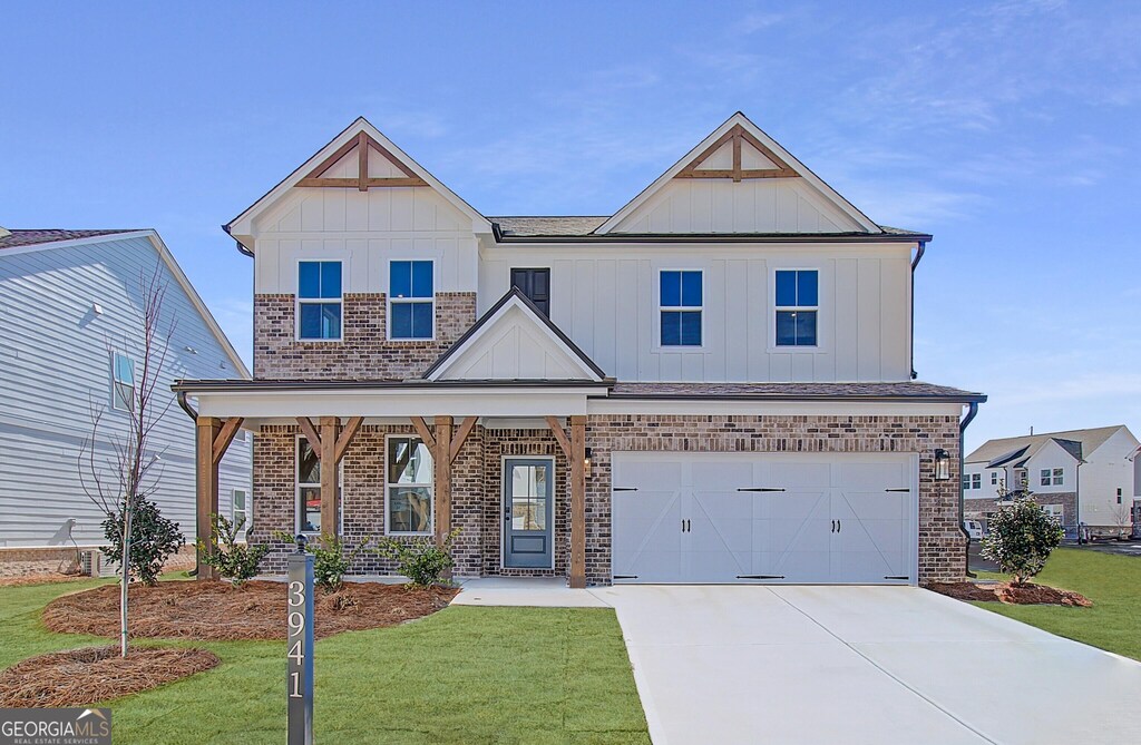 3941 Adler Cir Unit 24, Buford, GA 30519 - view of front of property featuring board and batten siding, concrete driveway, brick siding, and a front lawn
