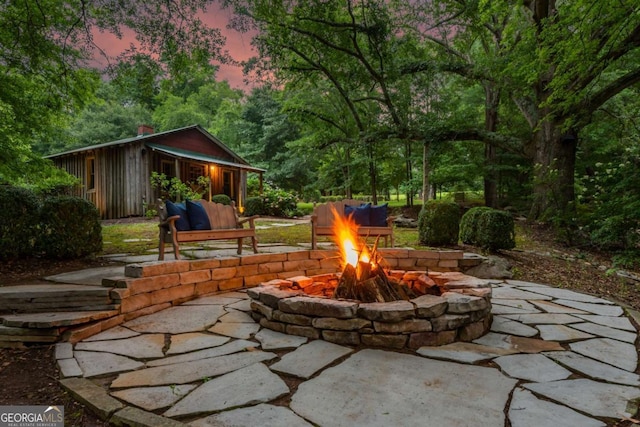 patio terrace at dusk featuring a fire pit