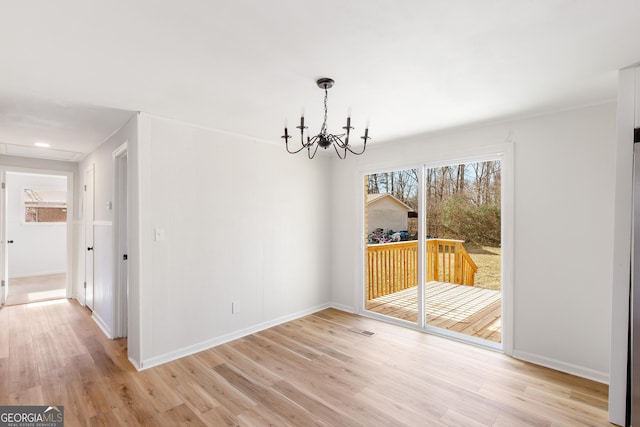 unfurnished dining area with light hardwood / wood-style flooring and a notable chandelier