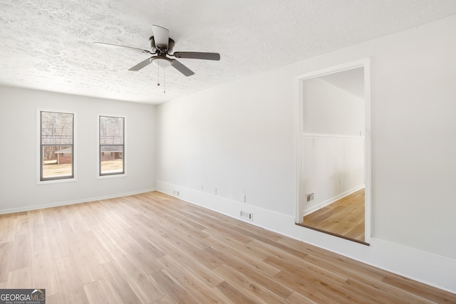 empty room featuring a textured ceiling, light hardwood / wood-style flooring, and ceiling fan