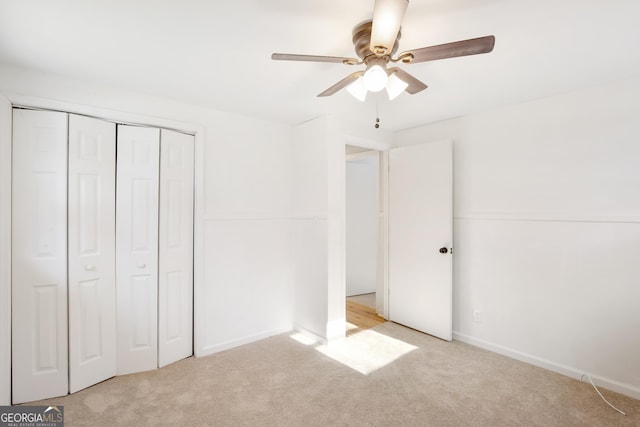 unfurnished bedroom with light carpet, a closet, and ceiling fan