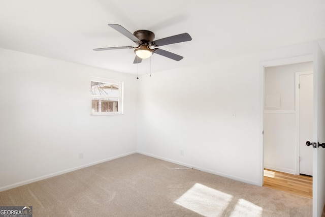 empty room with ceiling fan and light carpet