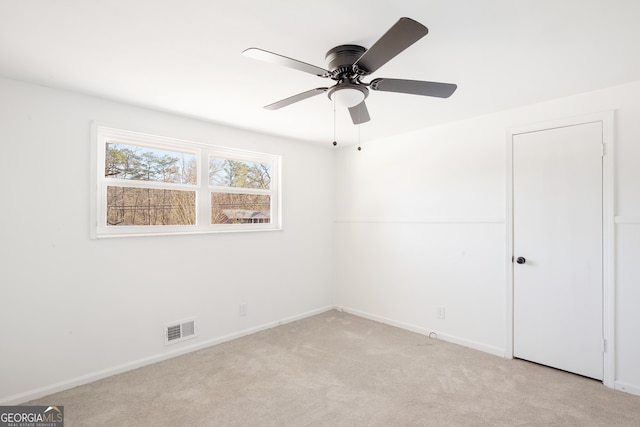 spare room featuring ceiling fan and light carpet