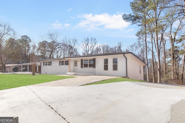 ranch-style house featuring a front lawn and a carport