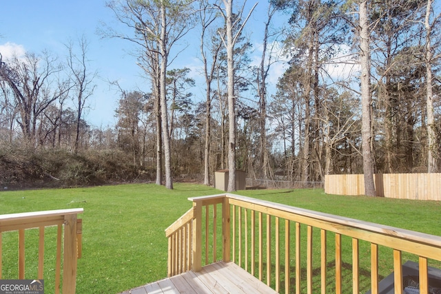 deck with a storage shed and a lawn