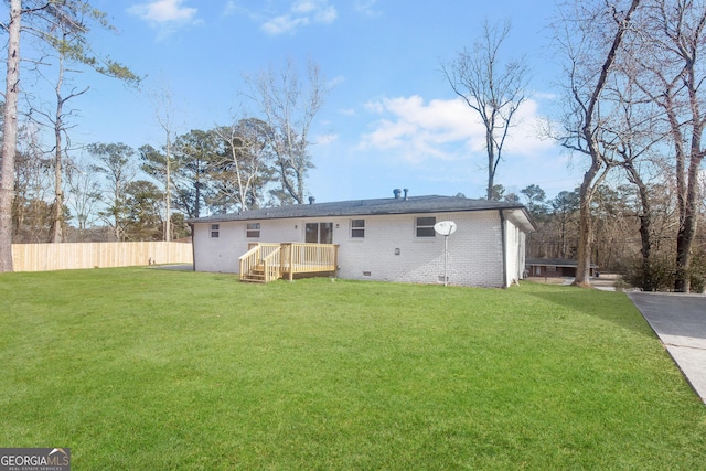 back of property featuring a wooden deck and a lawn