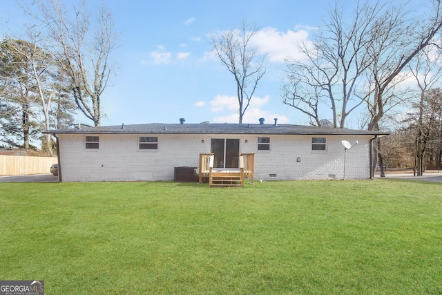 rear view of property with a lawn and cooling unit