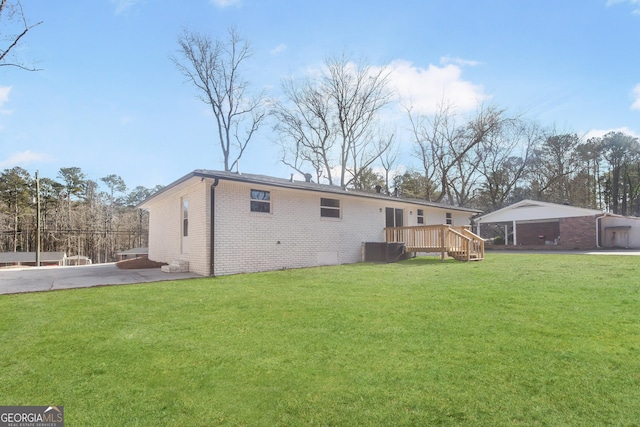 rear view of property featuring a deck and a lawn