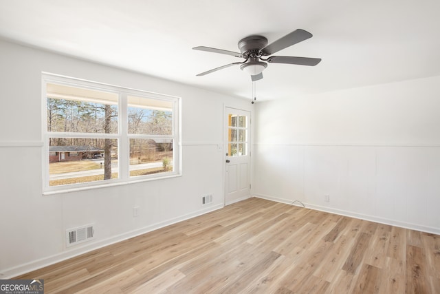 empty room with ceiling fan and light hardwood / wood-style flooring