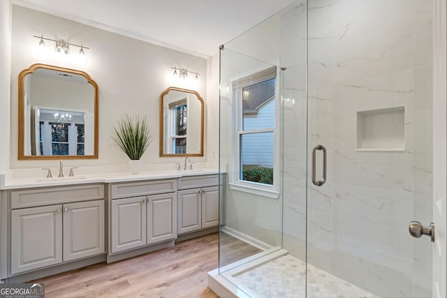 bathroom with hardwood / wood-style floors, a shower with door, and vanity