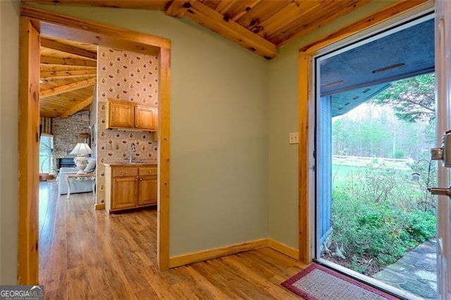 entryway with lofted ceiling with beams, sink, wood ceiling, and light hardwood / wood-style flooring