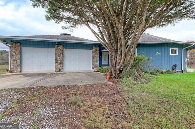 ranch-style house with a garage and a front yard