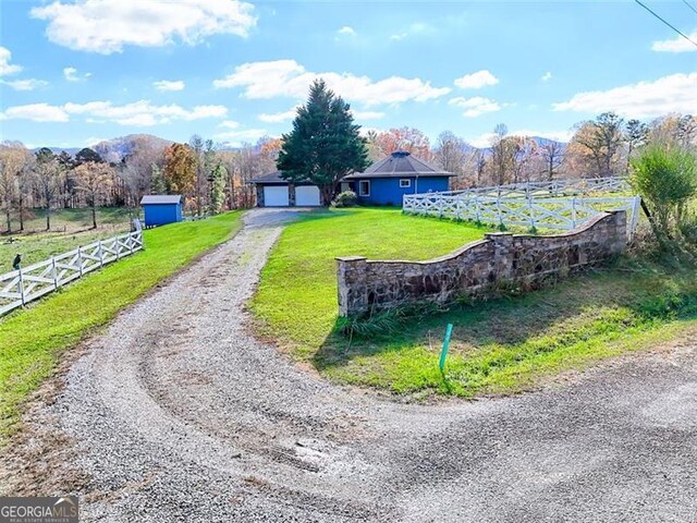 exterior space with a mountain view, a lawn, and a rural view