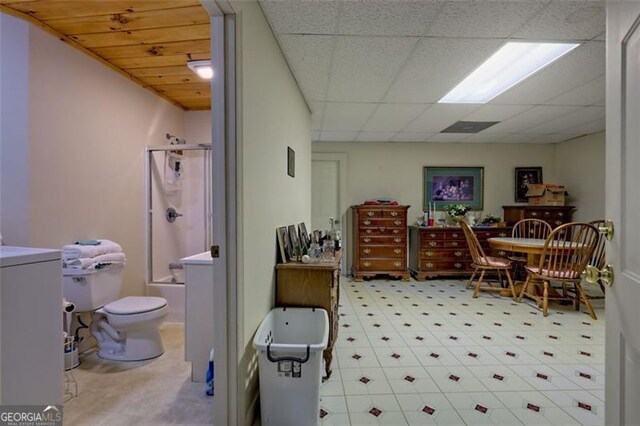 bathroom with shower / bath combination with glass door, a paneled ceiling, and toilet