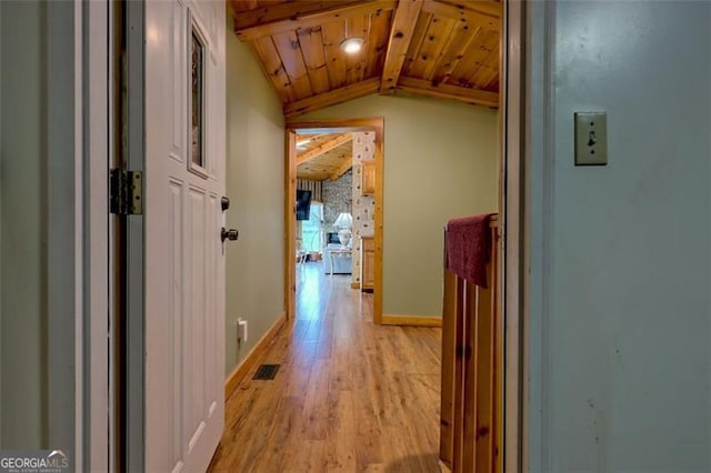 hall featuring lofted ceiling, wooden ceiling, and light wood-type flooring