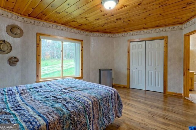 bedroom with wooden ceiling and light wood-type flooring