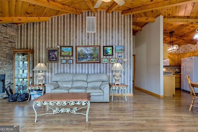 unfurnished living room featuring ceiling fan, a towering ceiling, and light hardwood / wood-style floors