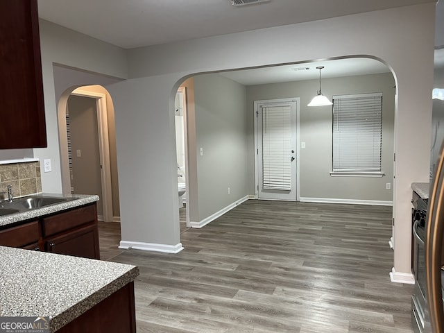 kitchen with sink, hardwood / wood-style floors, decorative backsplash, and dark brown cabinets