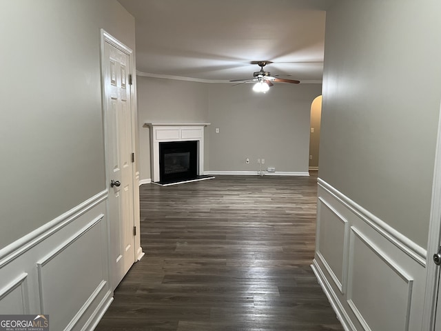 unfurnished living room featuring ceiling fan, ornamental molding, and dark wood-type flooring