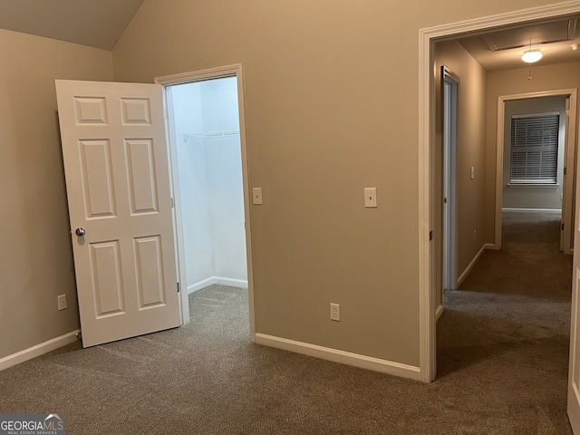 interior space featuring a closet, vaulted ceiling, carpet flooring, and a spacious closet