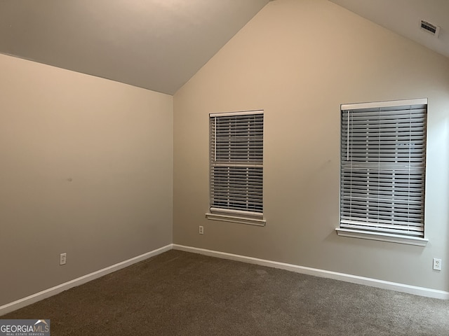 carpeted empty room featuring lofted ceiling