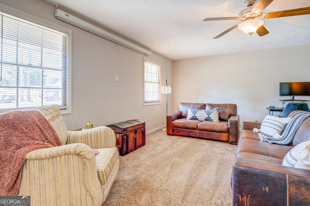 living room featuring ceiling fan, carpet, and a healthy amount of sunlight