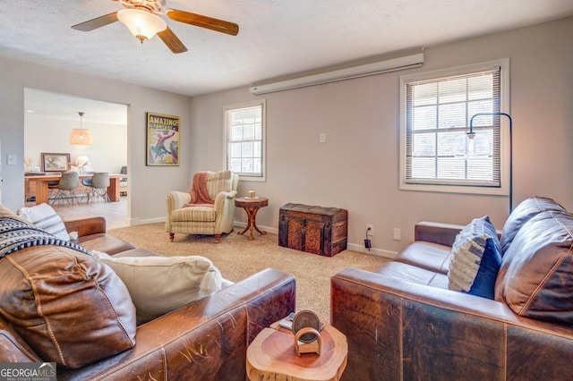 carpeted living room featuring ceiling fan, plenty of natural light, and a textured ceiling