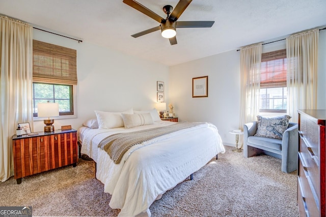 carpeted bedroom with multiple windows and ceiling fan