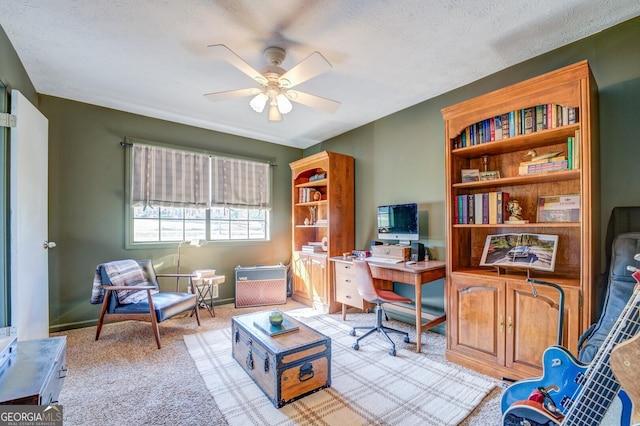 office featuring ceiling fan, a textured ceiling, and light carpet