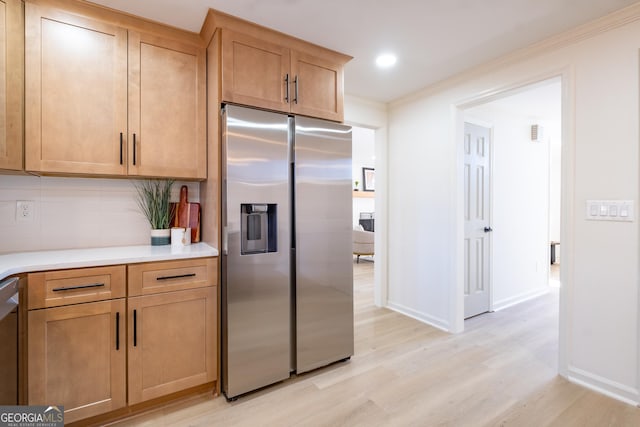 kitchen featuring appliances with stainless steel finishes, island exhaust hood, a healthy amount of sunlight, sink, and light wood-type flooring