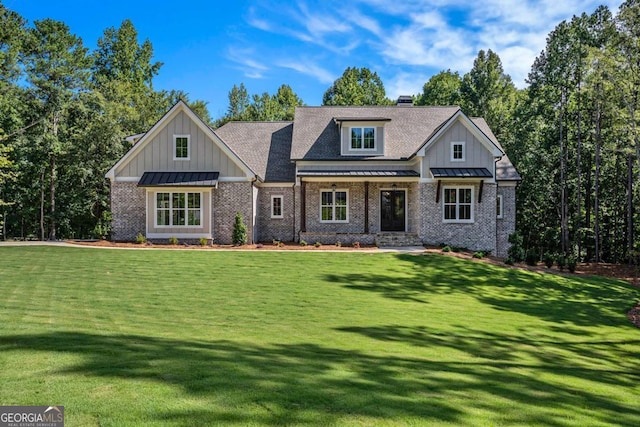 view of front facade featuring board and batten siding, a shingled roof, a front lawn, metal roof, and a standing seam roof