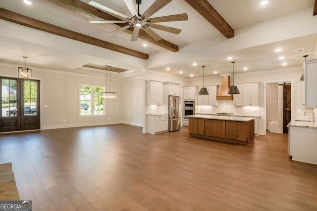 kitchen featuring white cabinets, a barn door, pendant lighting, and appliances with stainless steel finishes