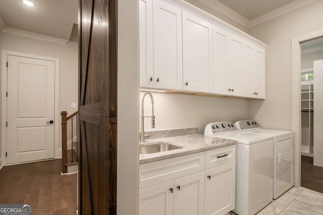 clothes washing area featuring sink, independent washer and dryer, cabinets, and ornamental molding