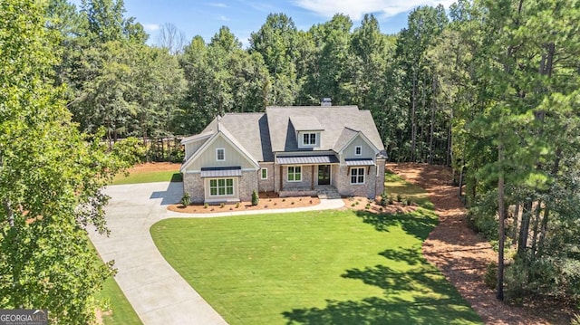 craftsman inspired home featuring board and batten siding, a front lawn, a standing seam roof, and metal roof