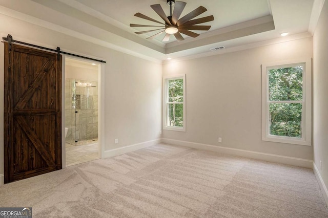 empty room featuring visible vents, crown molding, baseboards, light colored carpet, and a tray ceiling