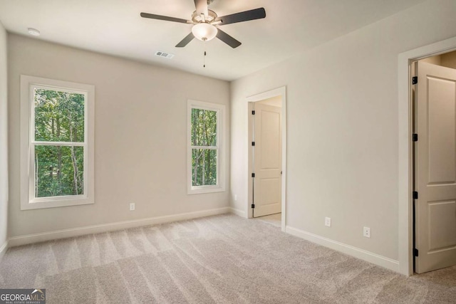 spare room featuring ceiling fan and light colored carpet