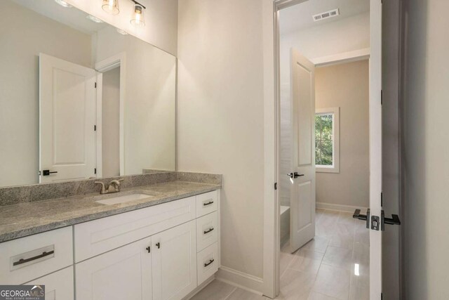 unfurnished bedroom featuring light carpet, ensuite bath, and ceiling fan