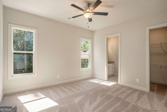 kitchen featuring light carpet, white cabinetry, ceiling fan, and built in desk