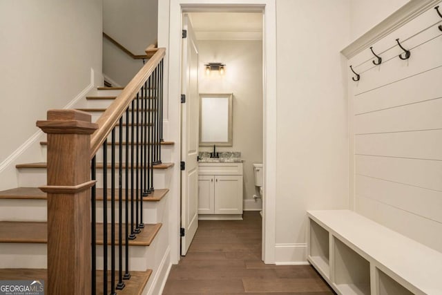 mudroom with dark wood-type flooring, baseboards, and a sink