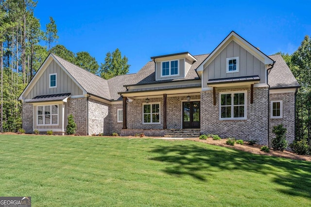 craftsman inspired home with brick siding, board and batten siding, a front yard, and a standing seam roof