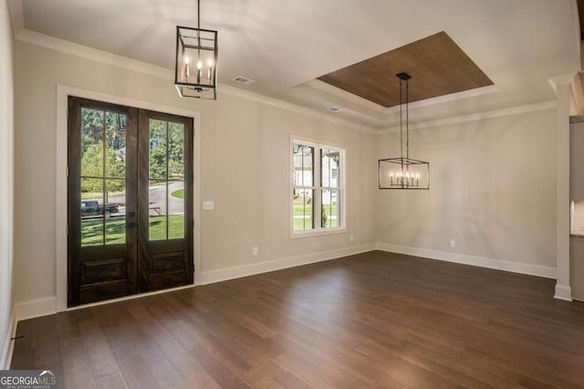 entryway with dark wood-style floors, visible vents, a tray ceiling, crown molding, and a chandelier